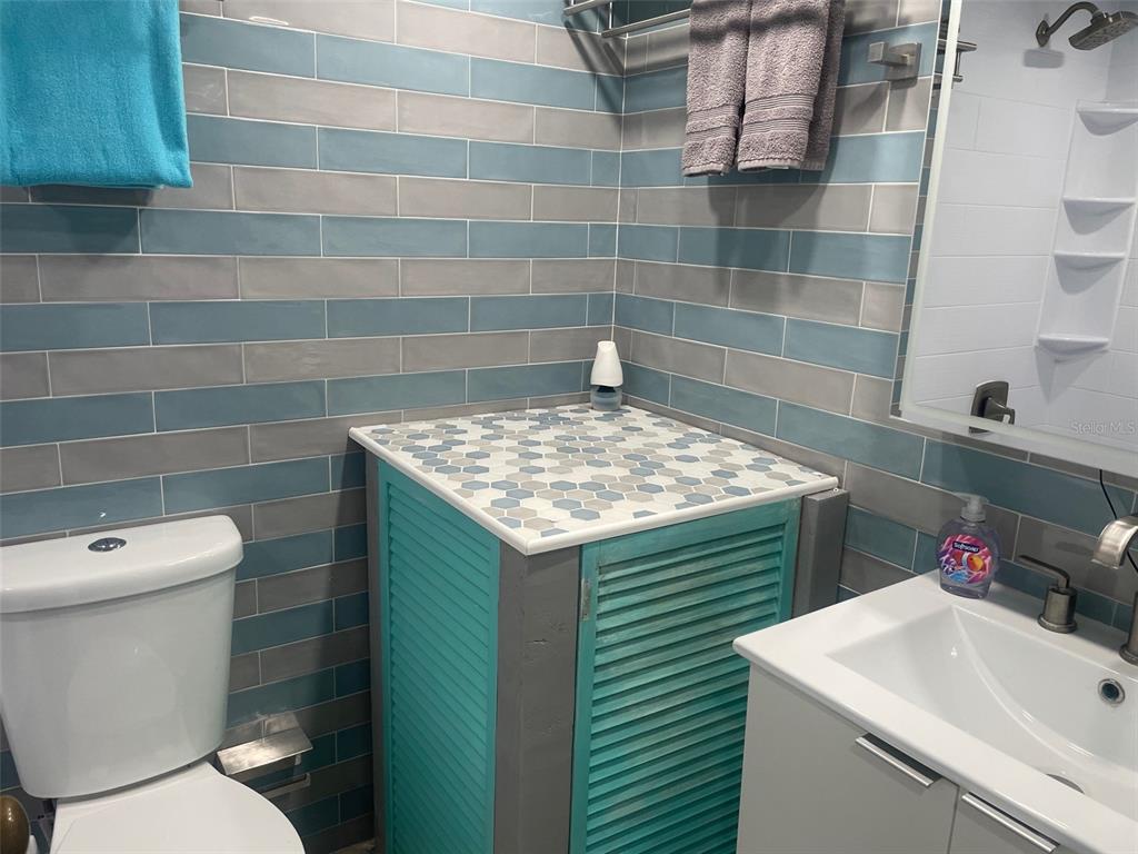 159 Medallion Boulevard, Unit E Madeira Beach, FL 33708 - Photo 8 of 15 a bathroom with a sink a toilet and a mirror