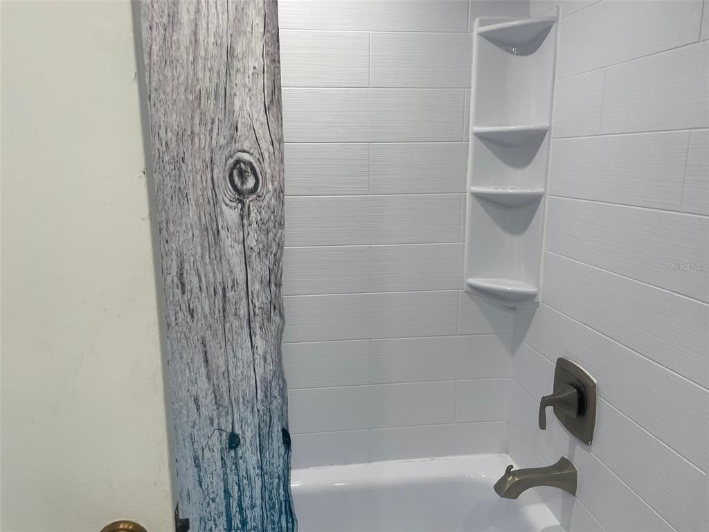 159 Medallion Boulevard, Unit E Madeira Beach, FL 33708 - Photo 9 of 15 a bathroom with a shower