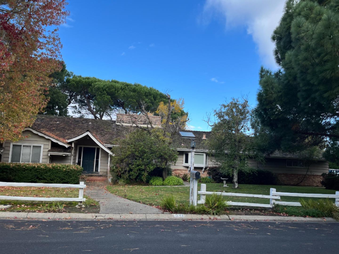 a view of house with a yard and large trees