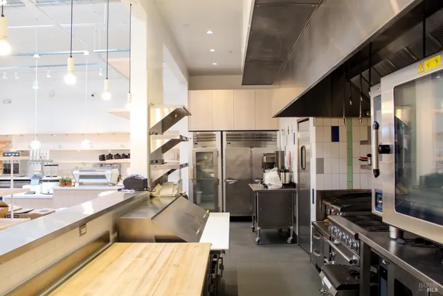 a kitchen with stainless steel appliances kitchen island granite countertop a sink and cabinets
