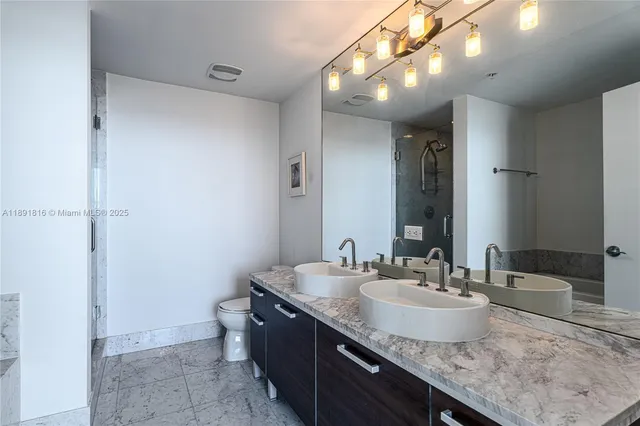 a bathroom with a granite countertop sink a toilet and a mirror