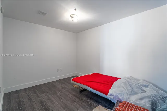 a room with a bed and a lamp with wooden floor