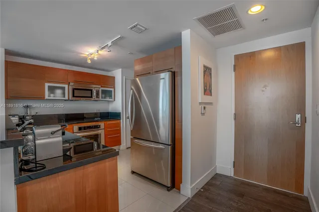 a kitchen with stainless steel appliances granite countertop a refrigerator and a stove top oven