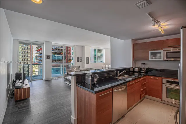 a kitchen with granite countertop a stove and chairs