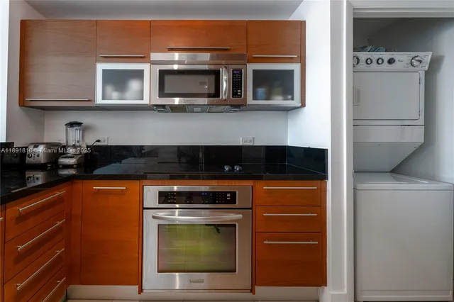 a kitchen with stainless steel appliances granite countertop a stove top oven microwave and cabinets