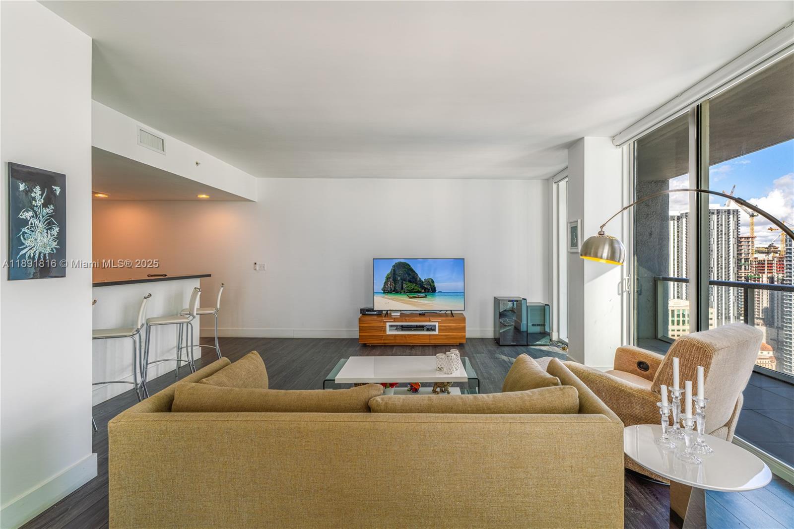 253 Northeast 2nd Street, Unit 3203 Miami, FL 33132 - Photo 10 of 29 a living room with furniture and a flat screen tv