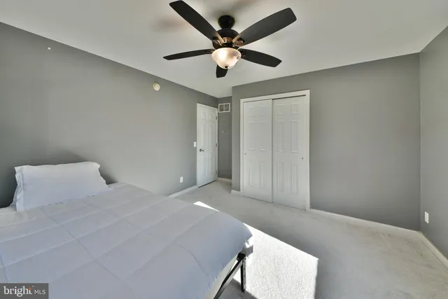 a bedroom with a bed and a ceiling fan