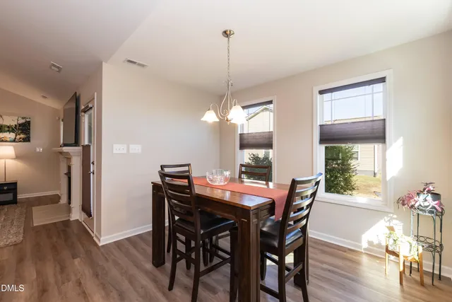 a dining room with furniture window wooden floor and a chandelier