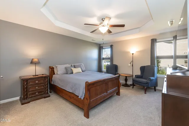 a spacious bedroom with a bed a chandelier and a couch
