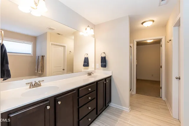 a bathroom with a double vanity sink and a mirror