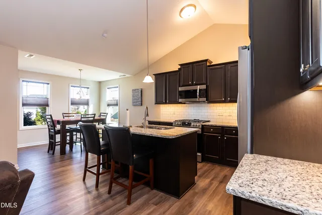 a kitchen with granite countertop kitchen island wooden cabinets and stainless steel appliances