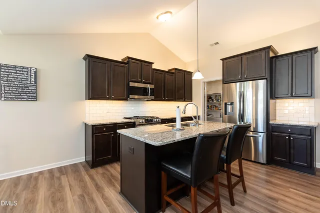 a kitchen with stainless steel appliances granite countertop a refrigerator stove microwave and sink