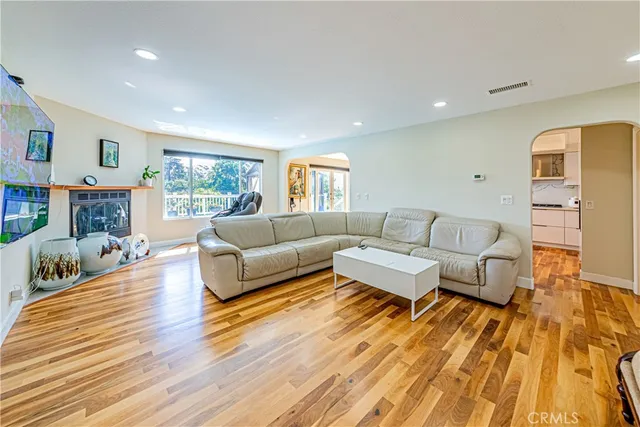 a living room with furniture and a wooden floor