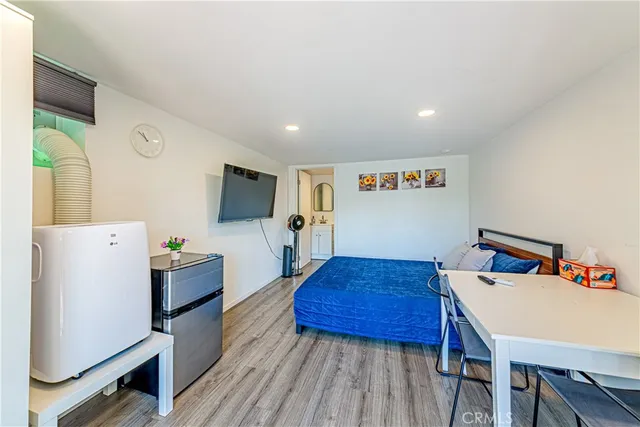 a bedroom with a large bed and a flat tv screen on a dresser