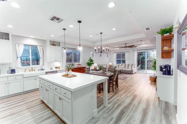 an open kitchen with stainless steel appliances granite countertop a lot of counter space and wooden floors
