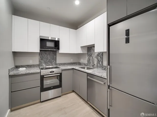 a kitchen with stainless steel appliances granite countertop a stove a sink and a refrigerator