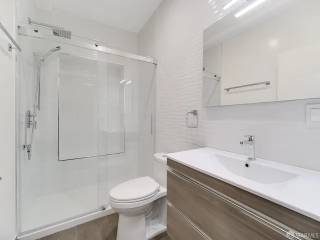 a bathroom with a sink a toilet and shower