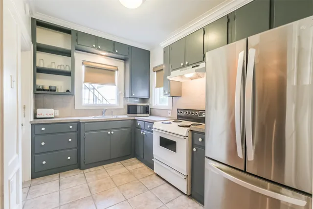 a kitchen with granite countertop a refrigerator and a stove top oven