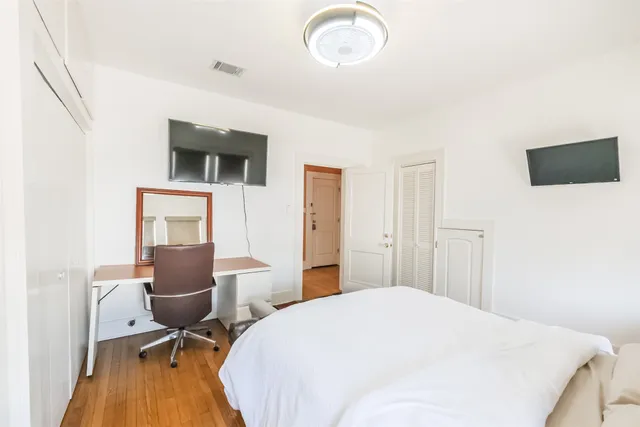 a bedroom with a bed and wooden floor