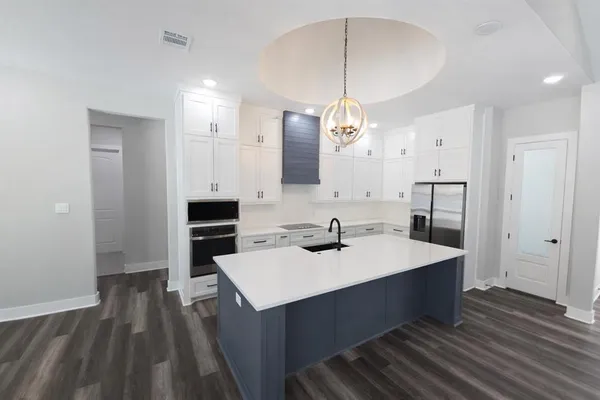 a kitchen with a sink refrigerator and microwave