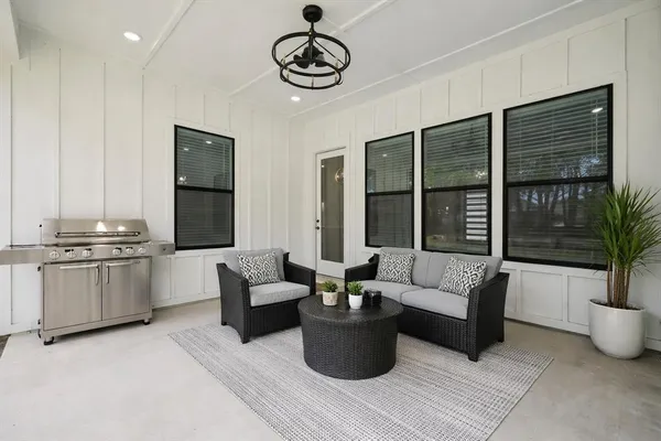 a living room with furniture potted plant and kitchen view