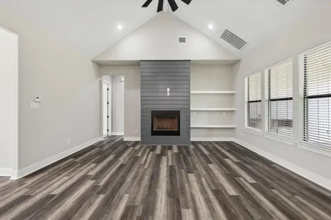 a view of a livingroom with wooden floor and a fireplace