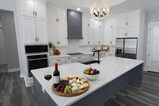 a kitchen with a sink a stove and white cabinets