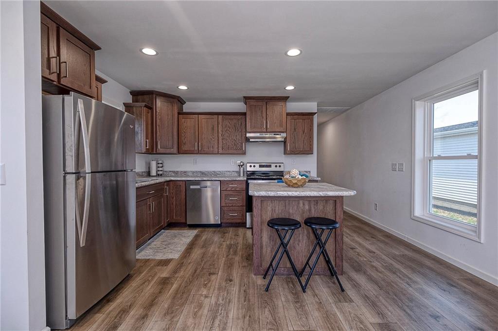 448 Motheral Avenue Monessen, PA 15062 - Photo 5 of 20 a kitchen with kitchen island wooden floors white appliances and cabinets
