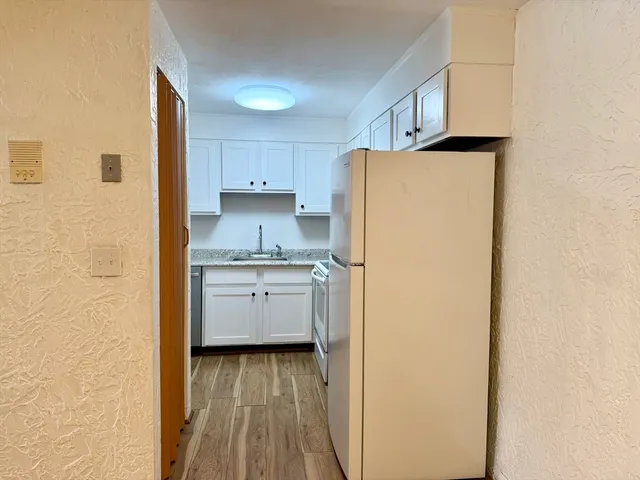 a kitchen with a refrigerator sink and cabinets