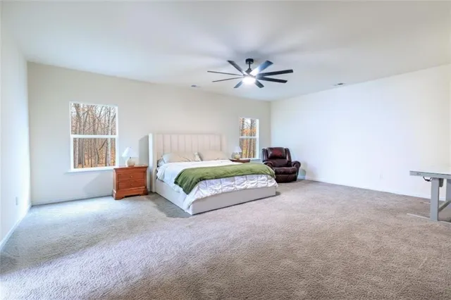 a bedroom with a bed ceiling fan and a window