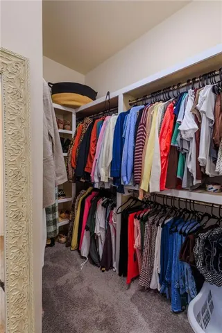 a view of walk in closet with clothes and shoes