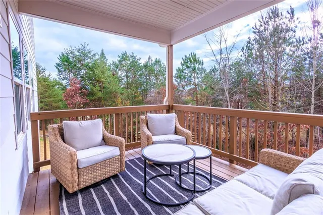 a balcony with wooden floor and outdoor seating