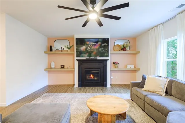 a living room with furniture a fireplace and a window