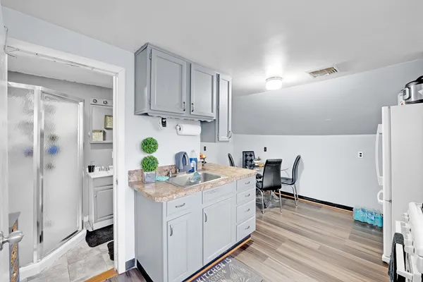 a view of kitchen with refrigerator stove and wooden floor