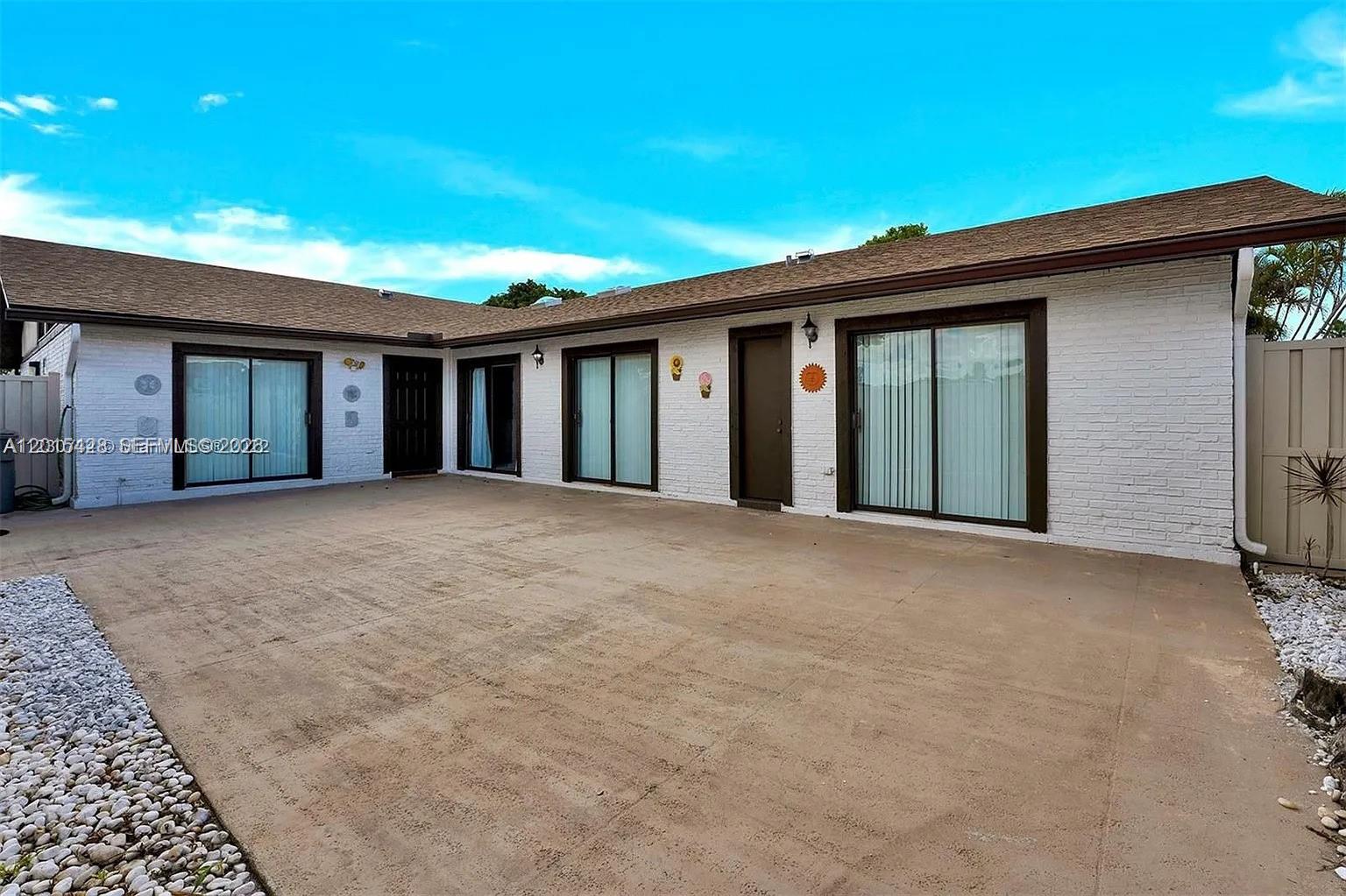 9892 Boca Gardens Parkway, Unit A Boca Raton, FL 33496 - Photo 1 of 32 front view of a house with a large window