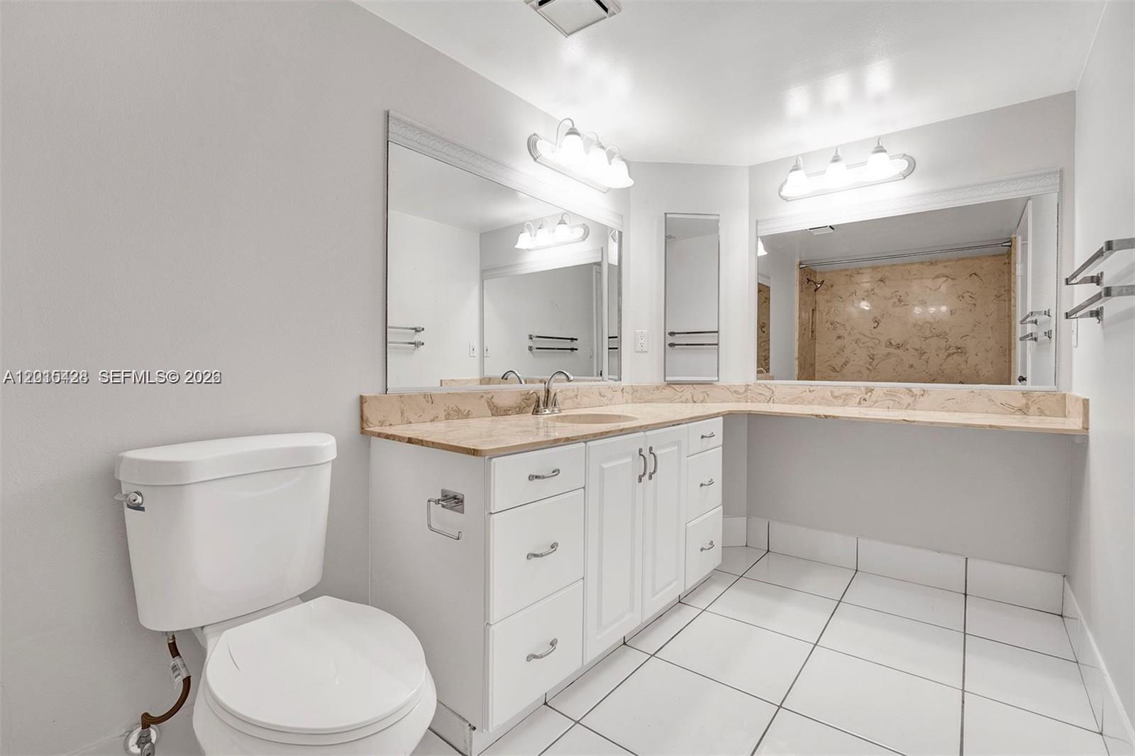 9892 Boca Gardens Parkway, Unit A Boca Raton, FL 33496 - Photo 17 of 32 a bathroom with a toilet a sink a mirror and a shower