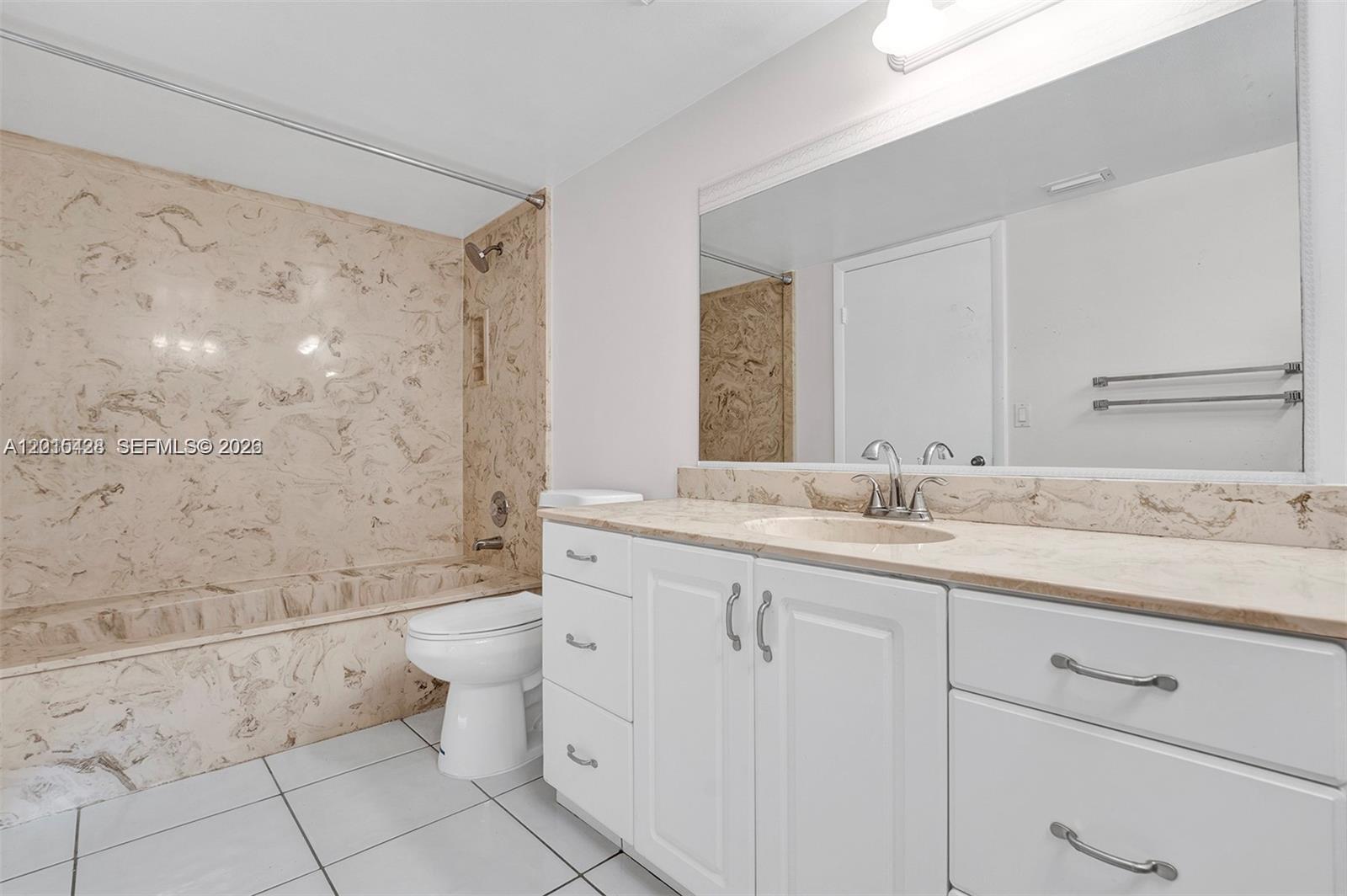 9892 Boca Gardens Parkway, Unit A Boca Raton, FL 33496 - Photo 18 of 32 a bathroom with a double vanity sink toilet and shower