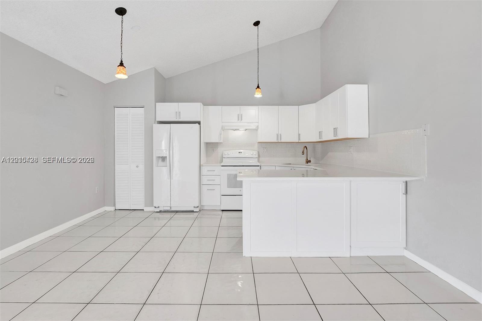 9892 Boca Gardens Parkway, Unit A Boca Raton, FL 33496 - Photo 7 of 32 a view of kitchen with white cabinets stainless steel appliances and a chandelier
