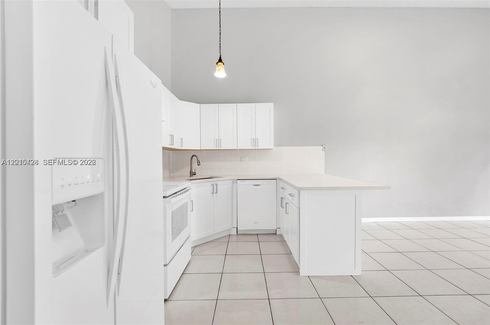 9892 Boca Gardens Parkway, Unit A Boca Raton, FL 33496 - Photo 9 of 32 a view of a kitchen with white cabinets and white appliances