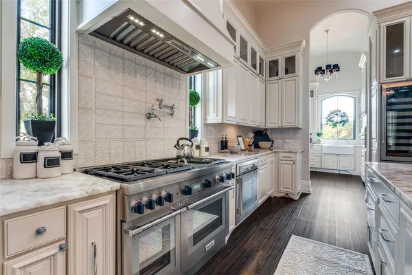 a kitchen with stainless steel appliances a stove a sink dishwasher and cabinets with wooden floor