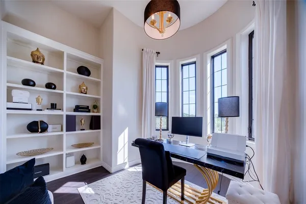 a view of a workspace with furniture and a window