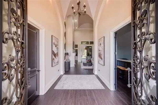 a view of a hallway with wooden floor and a living room