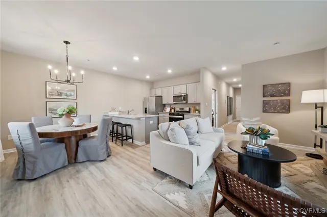 a living room with furniture a dining table and kitchen view