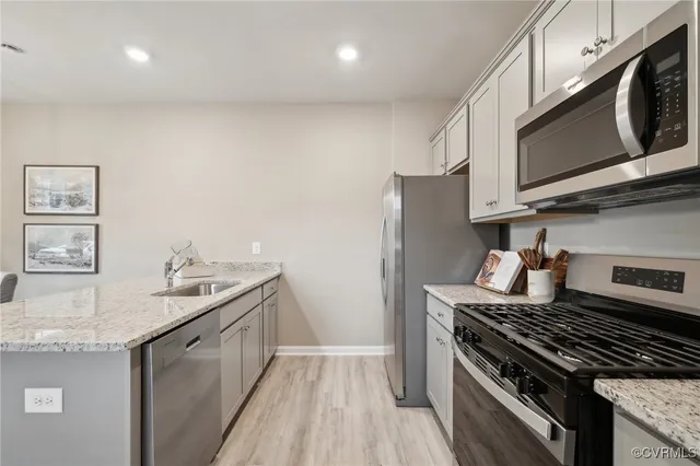 a kitchen with stainless steel appliances granite countertop a stove a sink and a microwave
