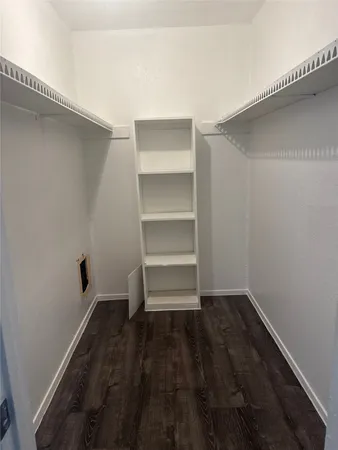 an empty room with wooden floor and closet