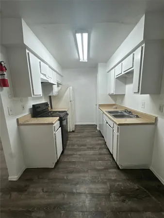 a kitchen with sink a stove and cabinets