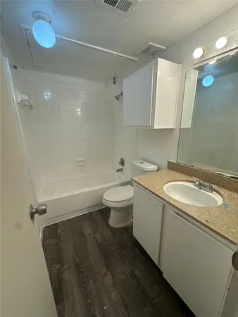 a bathroom with a granite countertop sink a toilet and shower