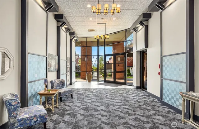 a living room with furniture a chandelier and a floor to ceiling window
