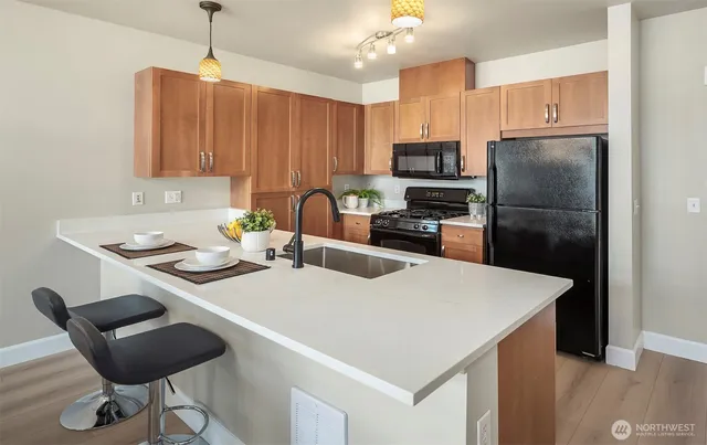 a kitchen with stainless steel appliances a stove a refrigerator a sink and a table