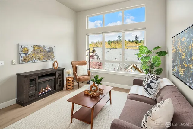 a living room with furniture a fireplace and a large window